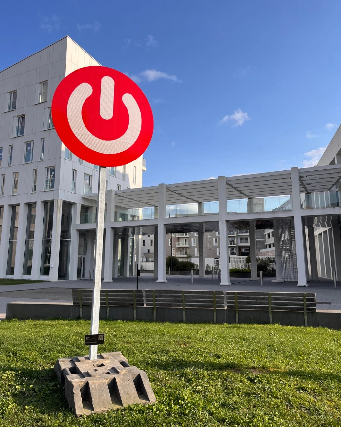 Symbole power détourné en sculpture urbaine, série SIGNAL, œuvre d’Olivier Deruyttere